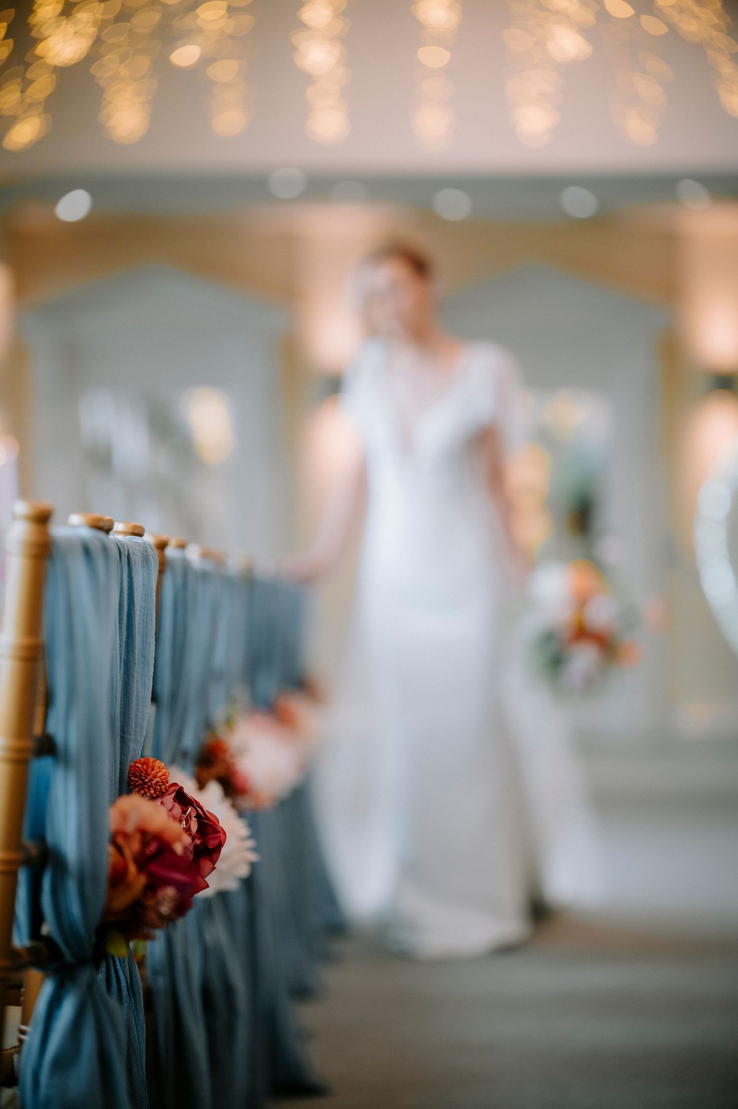 Dreamy wedding venue setup with twinkling lights and blue chair decorations.