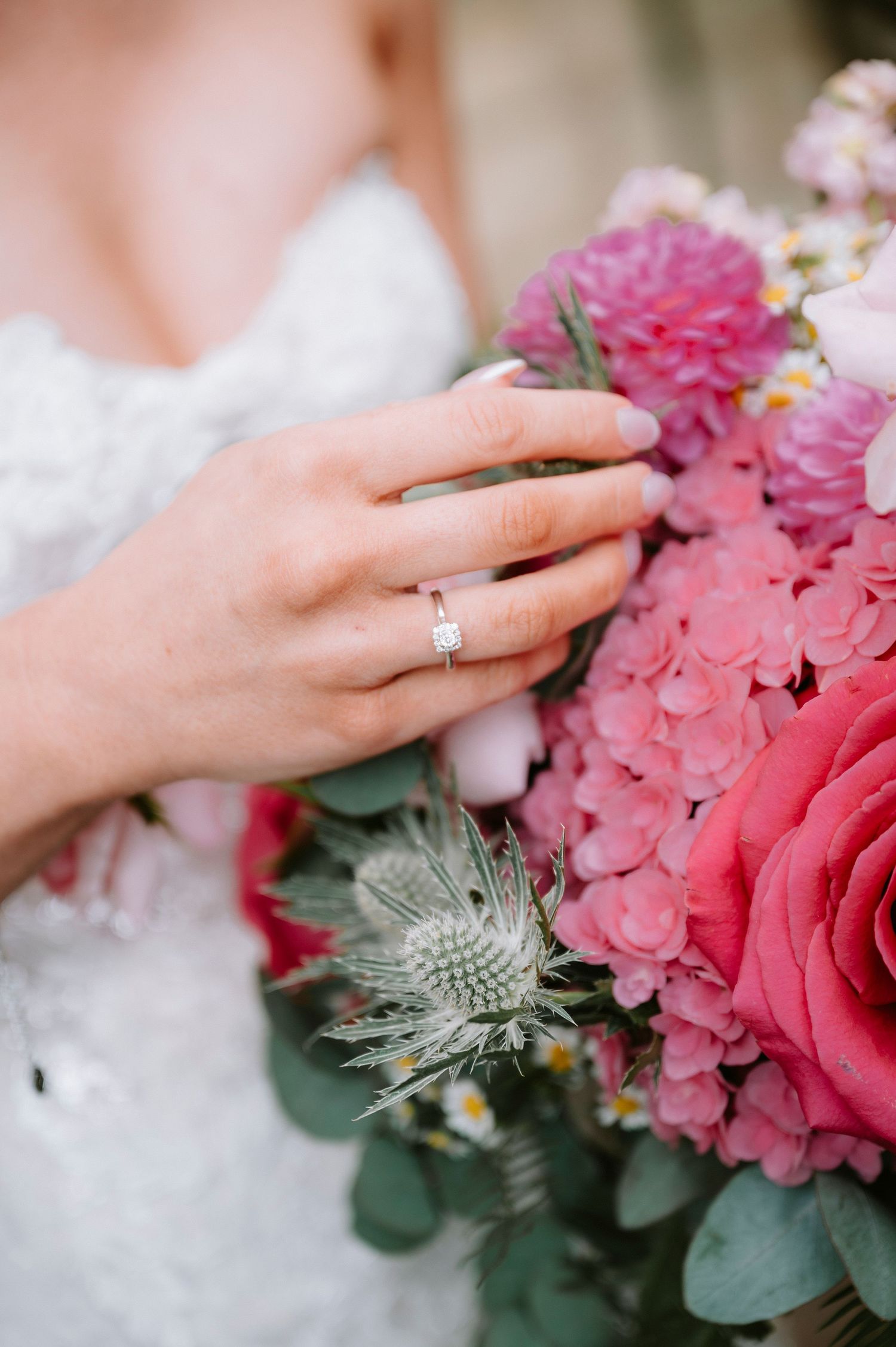 Close-up of engagement ring with pink roses and thistle bouquet details.