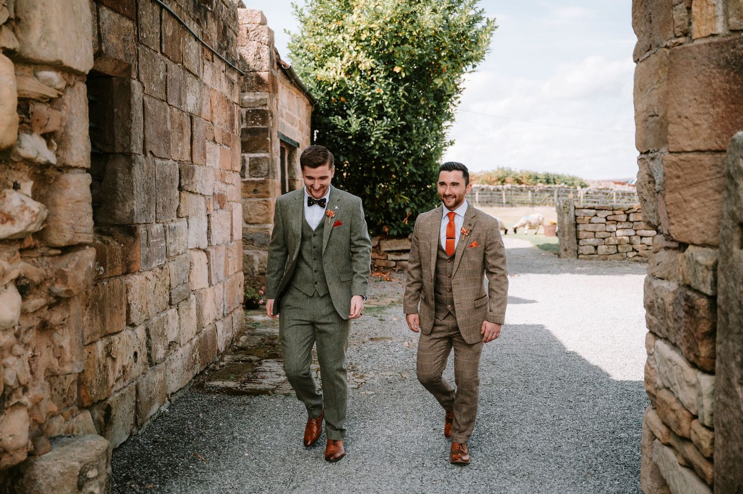 Wedding party walking through rustic stone archways and corridors.
