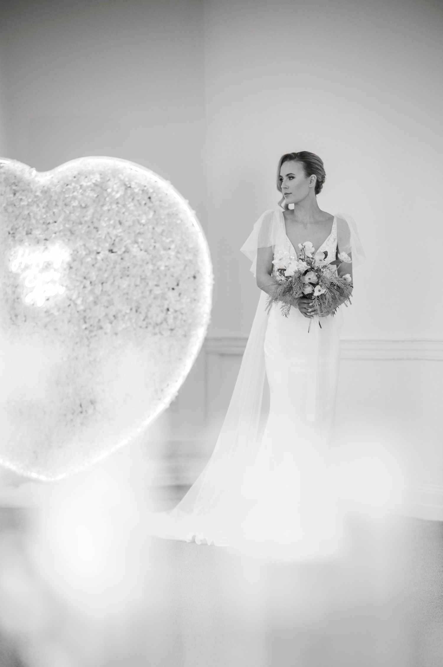 Black and white wedding photos with artistic bokeh effects capture elegant bridal moments.