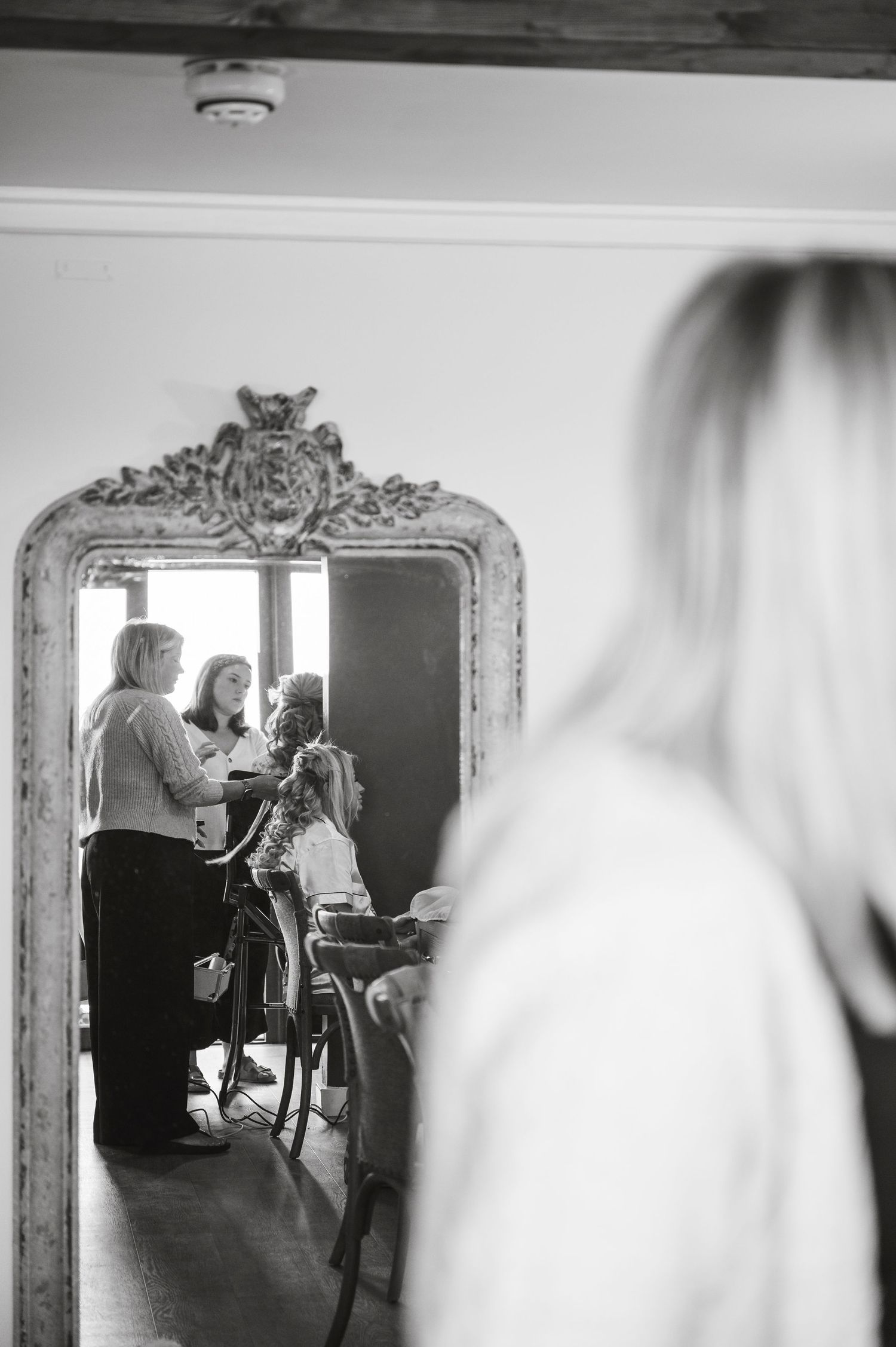 Black and white photos show wedding preparation moments reflected in an ornate mirror during morning preparations.