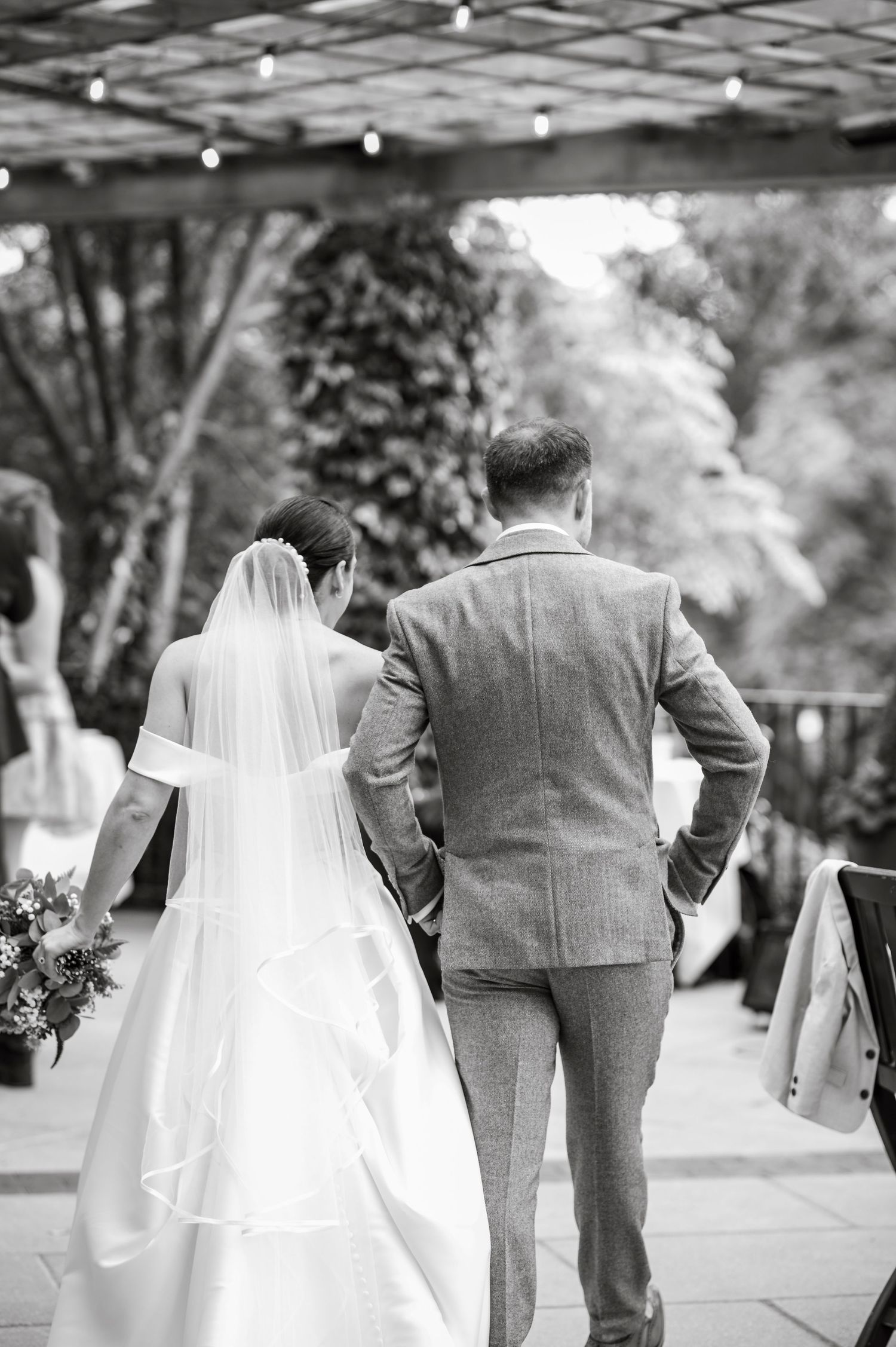 Wedding couple walks together on outdoor path in romantic setting.