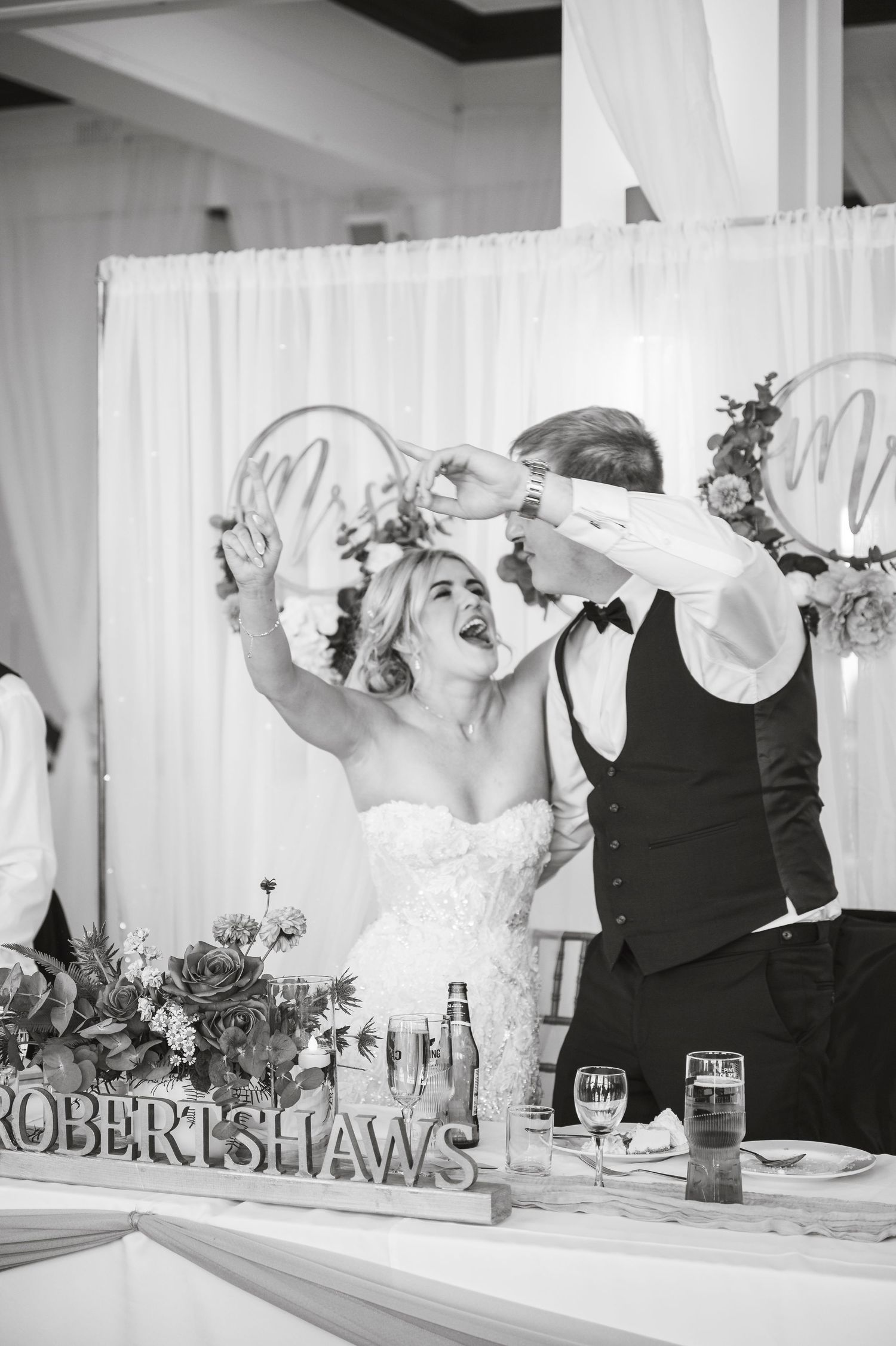 Black and white photo of wedding guests waving napkins at an elegant reception.