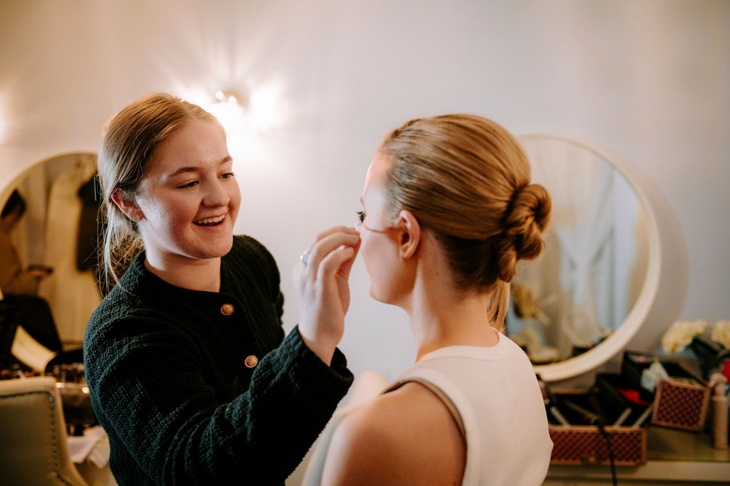 Behind-the-scenes wedding preparation showing styling and makeup application.