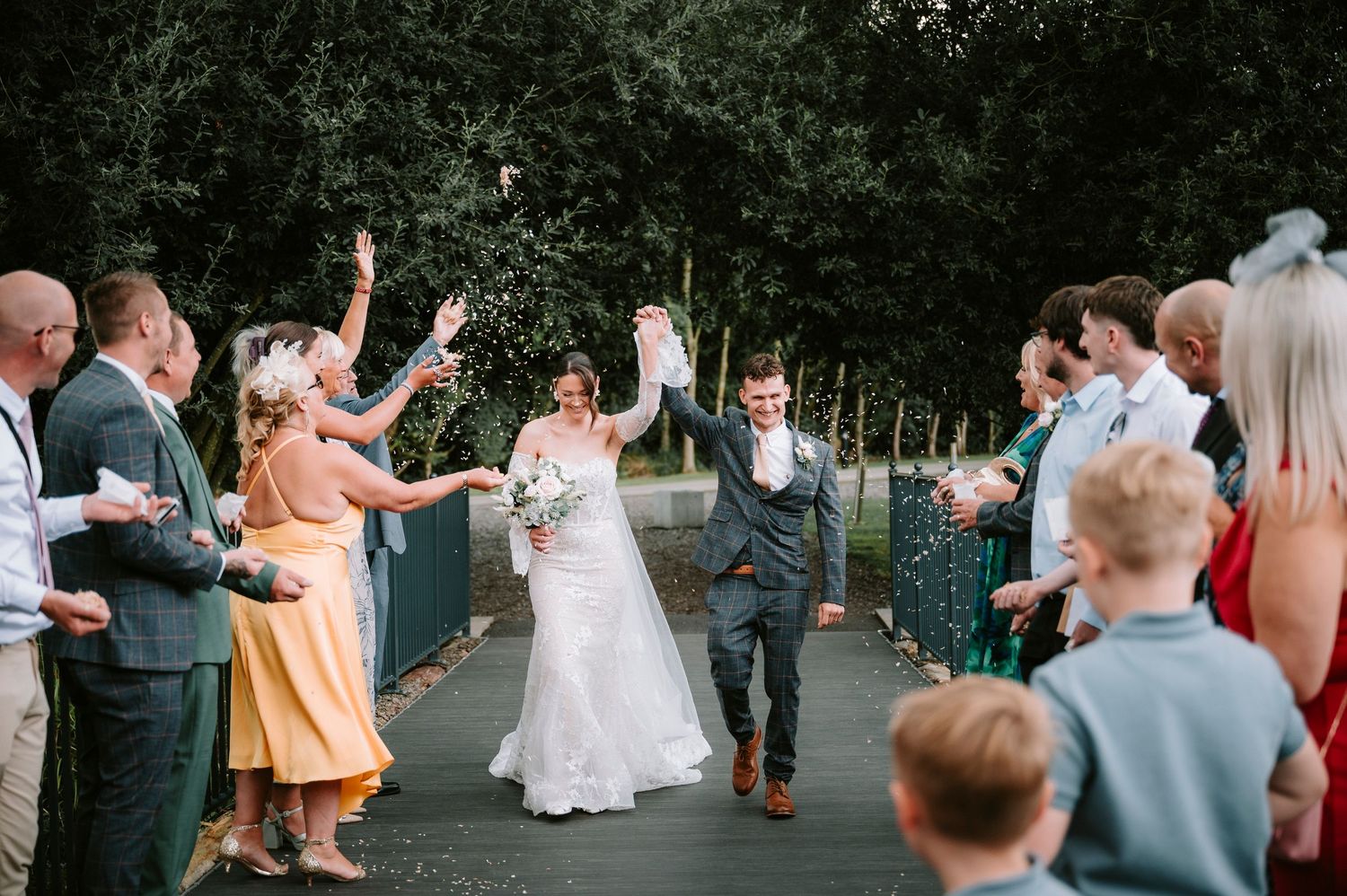 Wedding guests mingling and celebrating outdoors on a sunny afternoon.