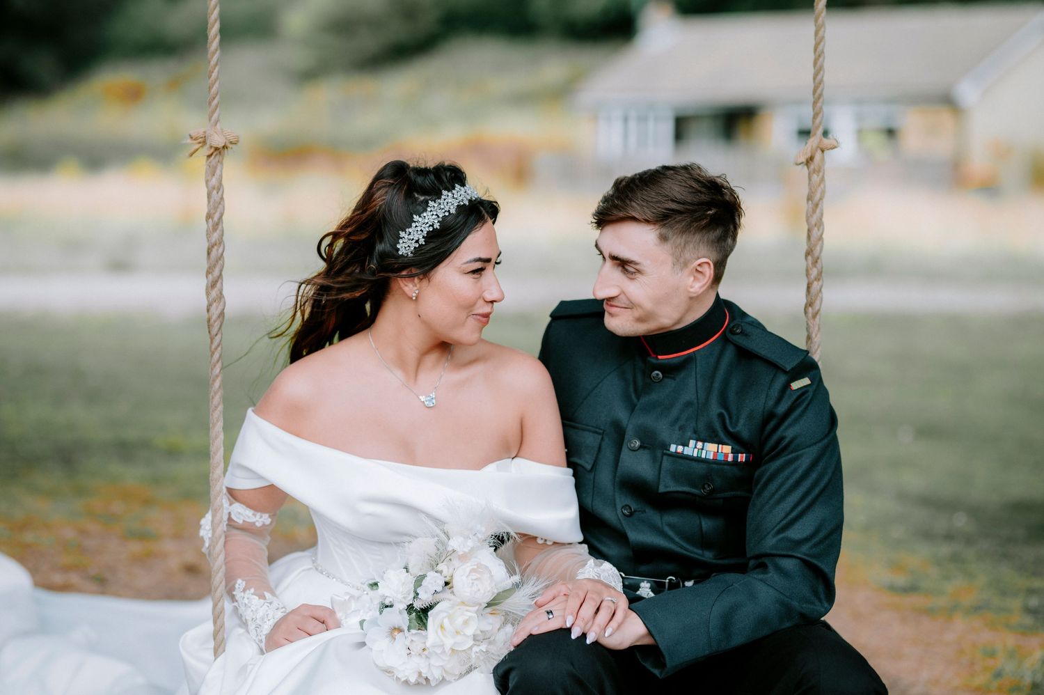 Couple sitting together on a rustic swing during their wedding photoshoot.