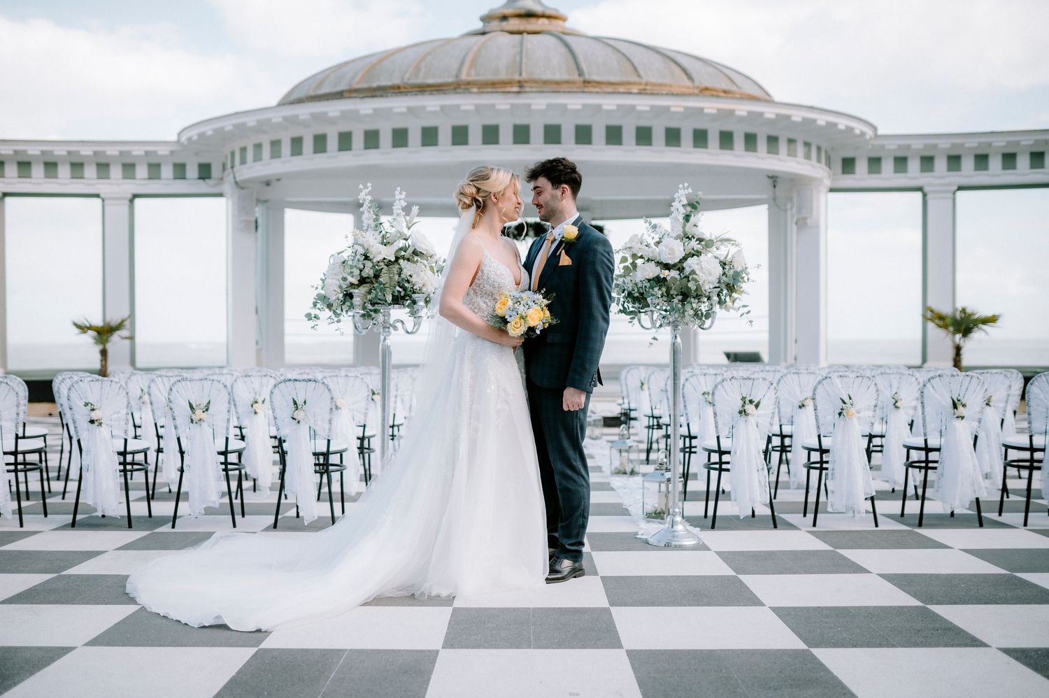 Spacious wedding venue with checkered floor and domed ceiling featuring classic decor.