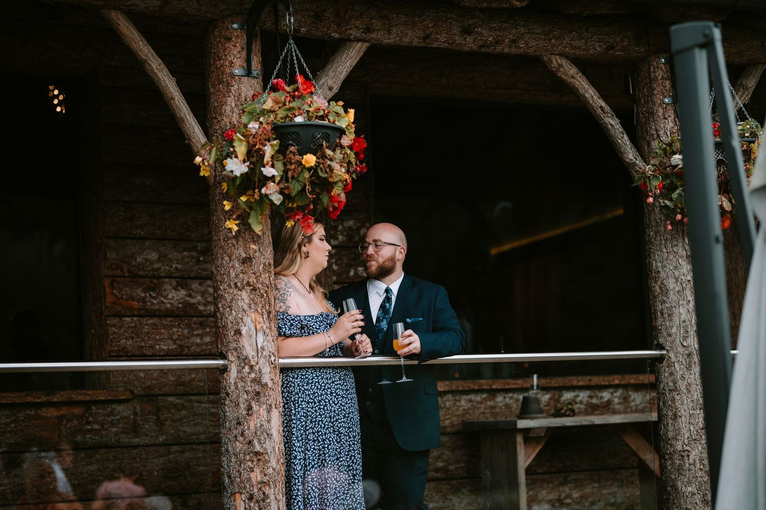 Rustic barn wedding ceremony setup with floral decorations and wooden beams.
