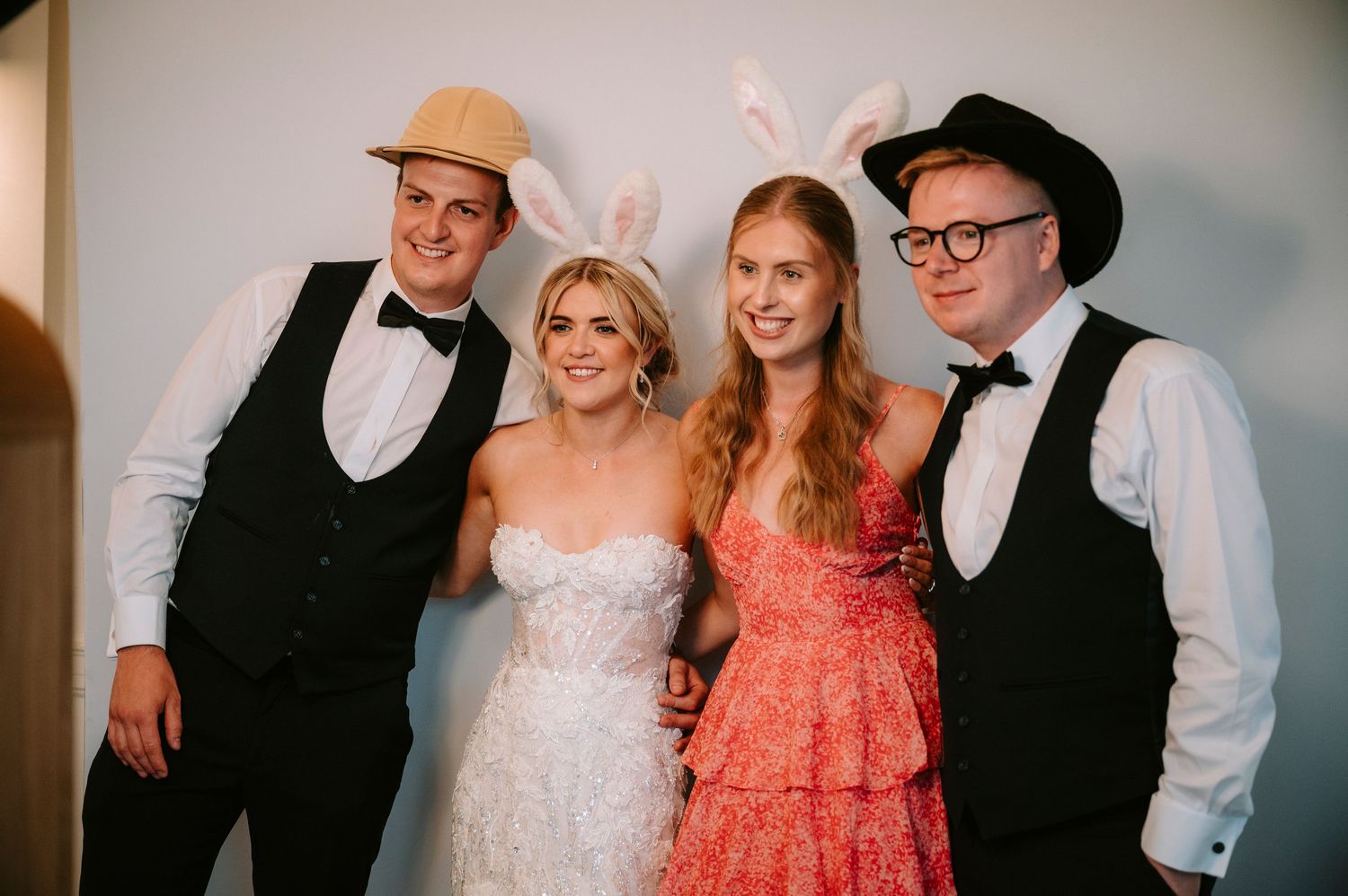 Wedding party poses together in formal attire with cowboy hats and western-inspired outfits.