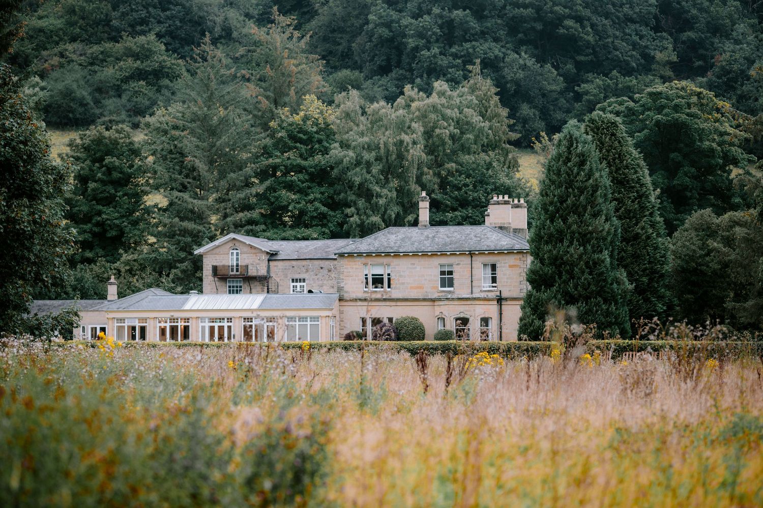 Panoramic view of historic buildings nestled among trees in a rural landscape.