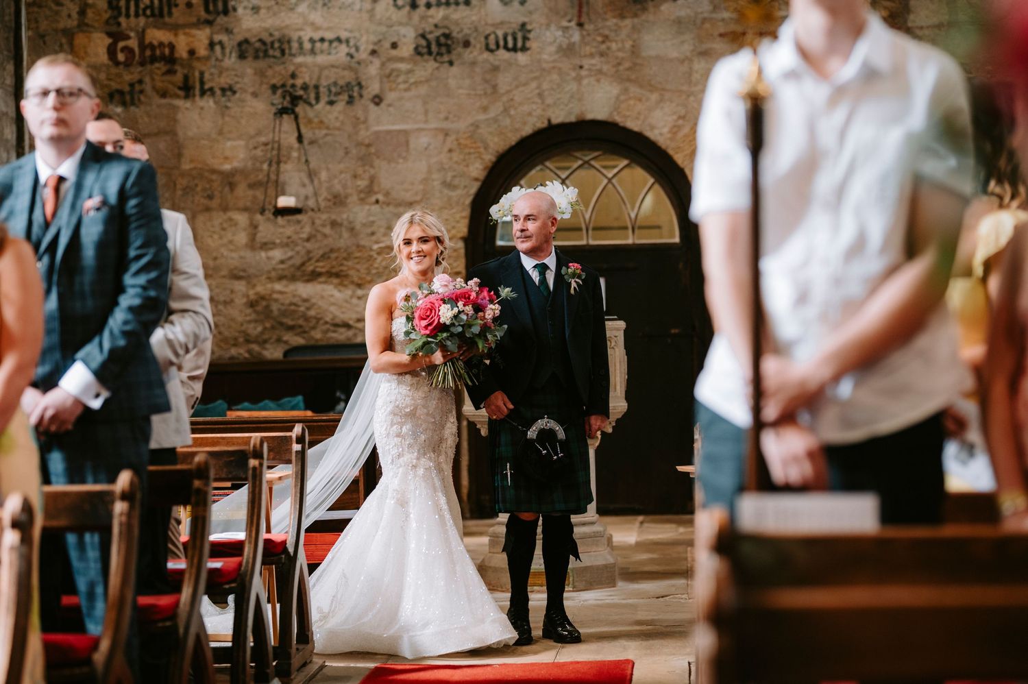 Wedding ceremony in progress inside historic stone church with traditional decor.