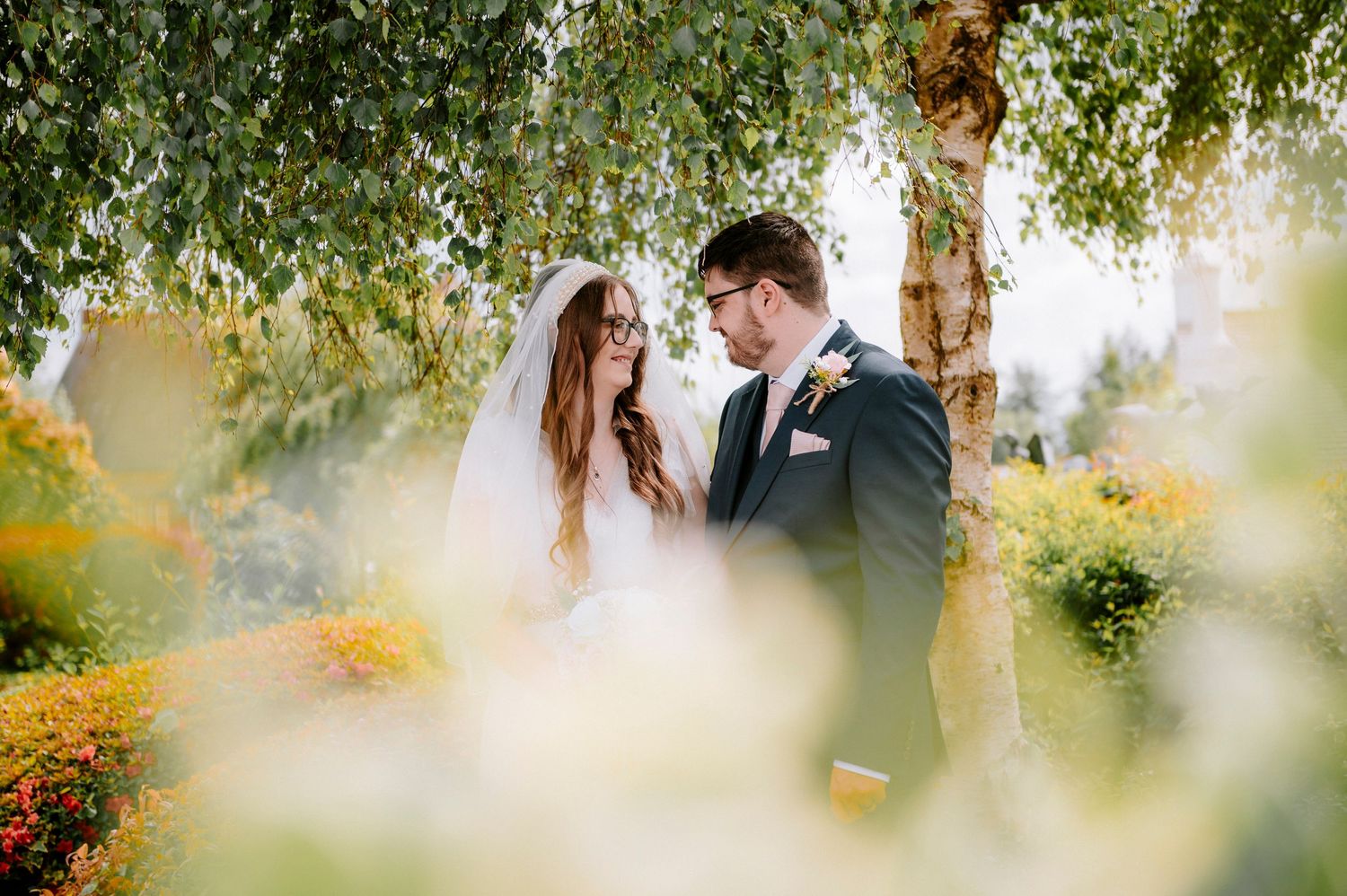 Romantic outdoor wedding portraits with soft bokeh effect and natural greenery.