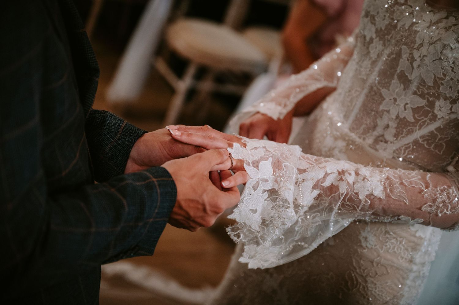 Close-up detail of intricate lace pattern on wedding dress.