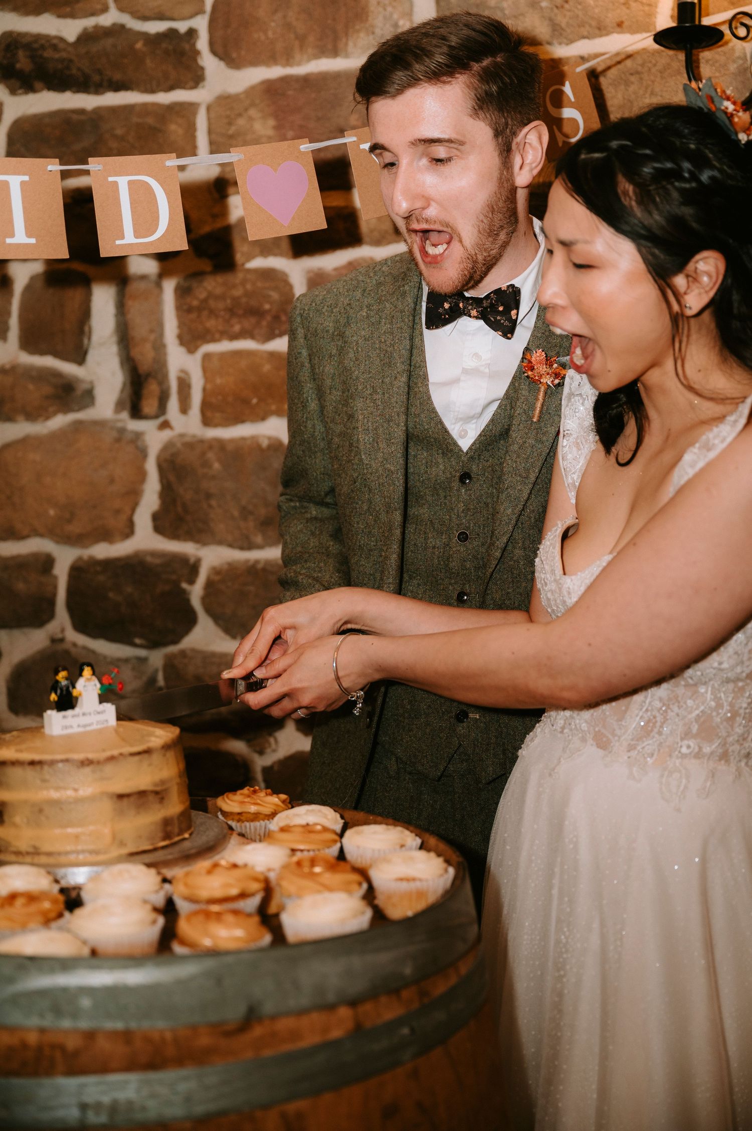 Wedding celebration with desserts displayed on rustic wooden barrels.