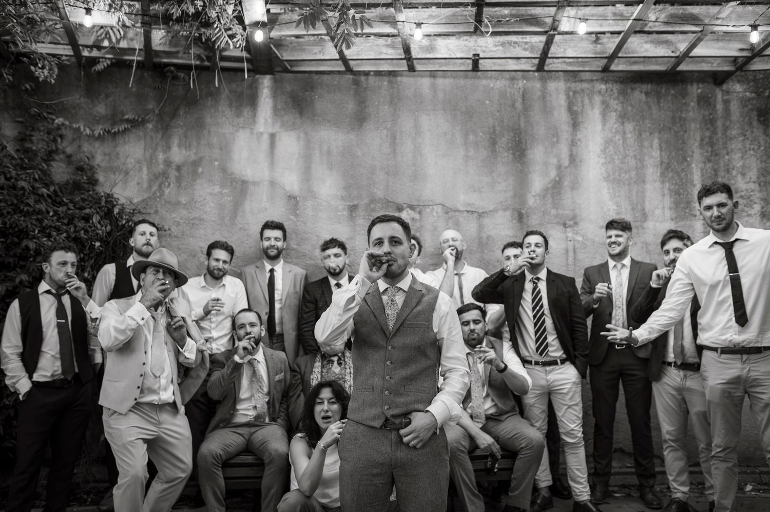 A black and white group photo of wedding guests posing together.