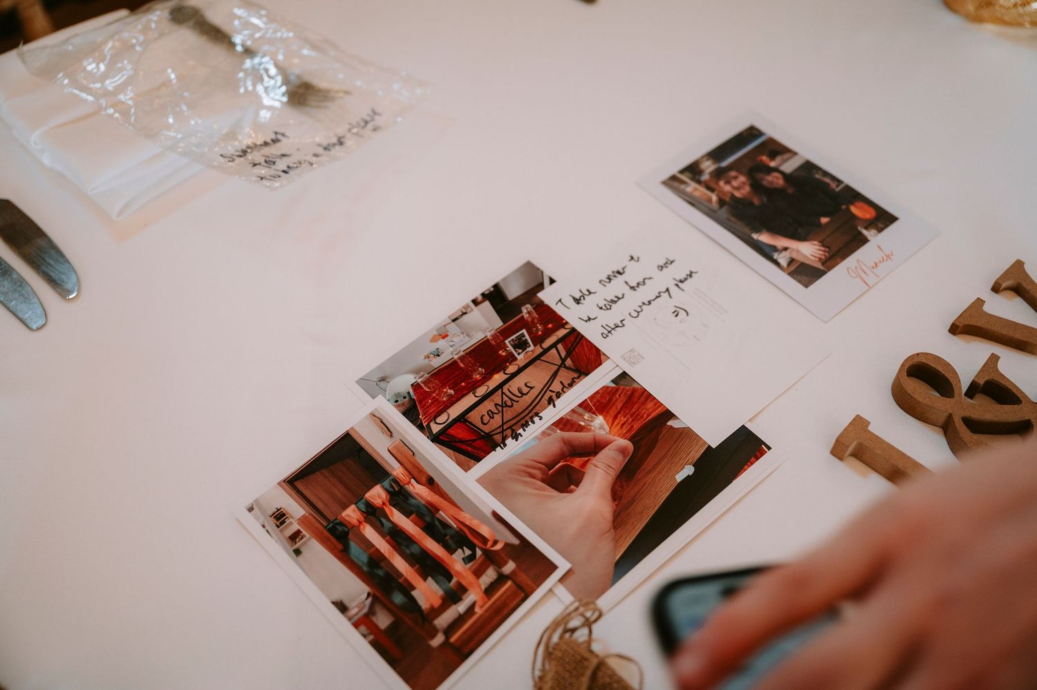 Wedding guest book and photo display on a white table with handwritten messages.