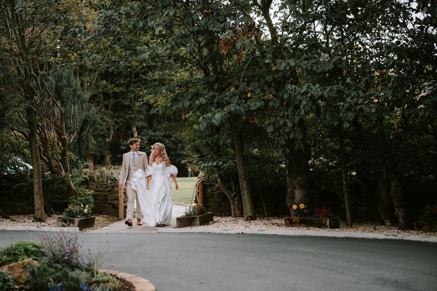 Romantic garden pathway surrounded by lush trees and greenery for wedding photos.
