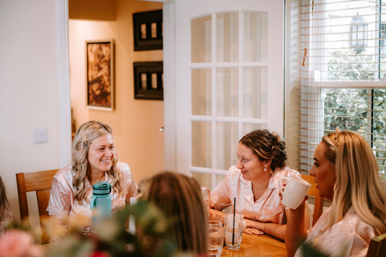 Candid moments shared during wedding day preparations in a sunlit room.