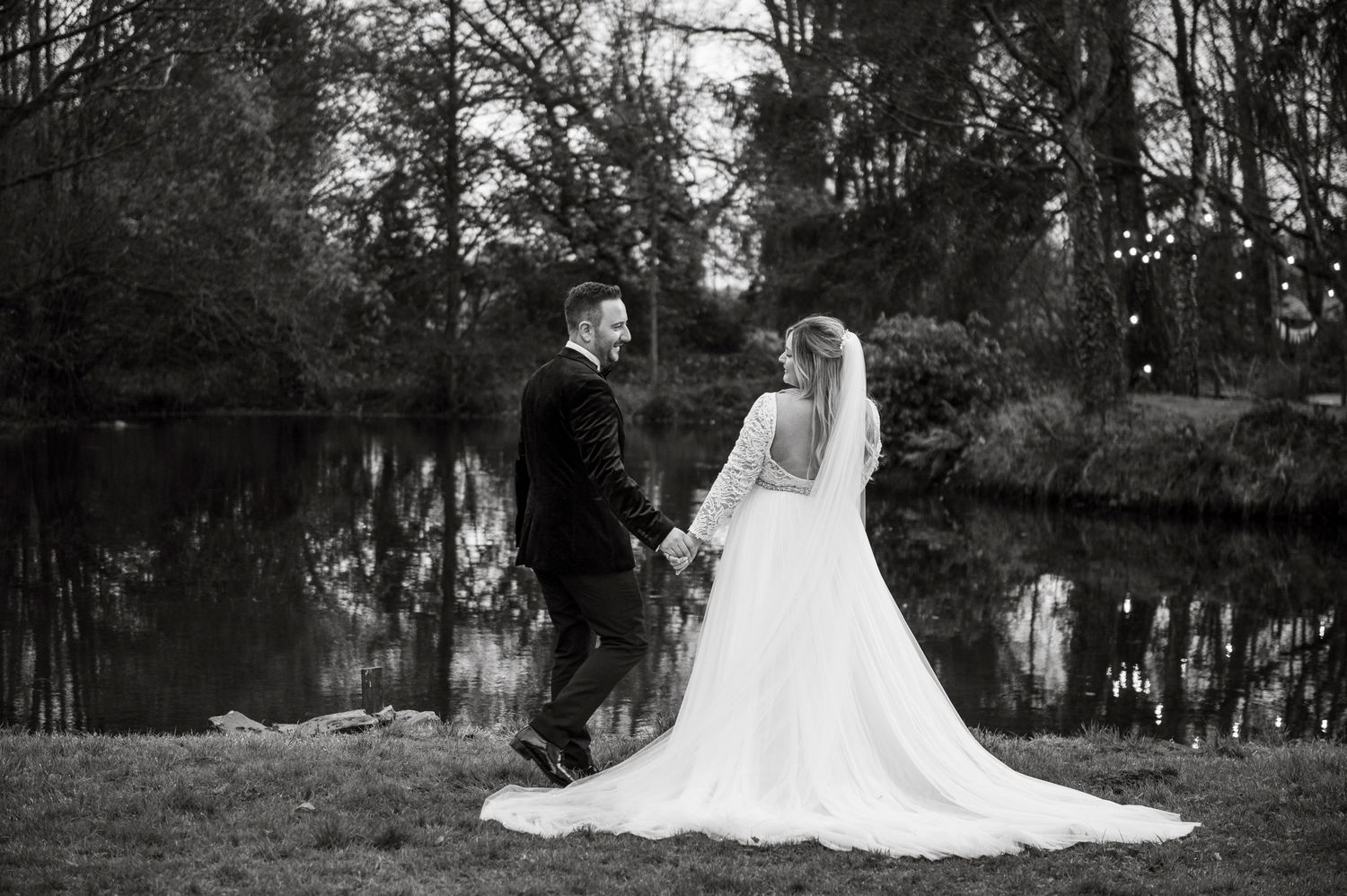 A scenic wedding photoshoot in a wooded area with dramatic black and white tones.
