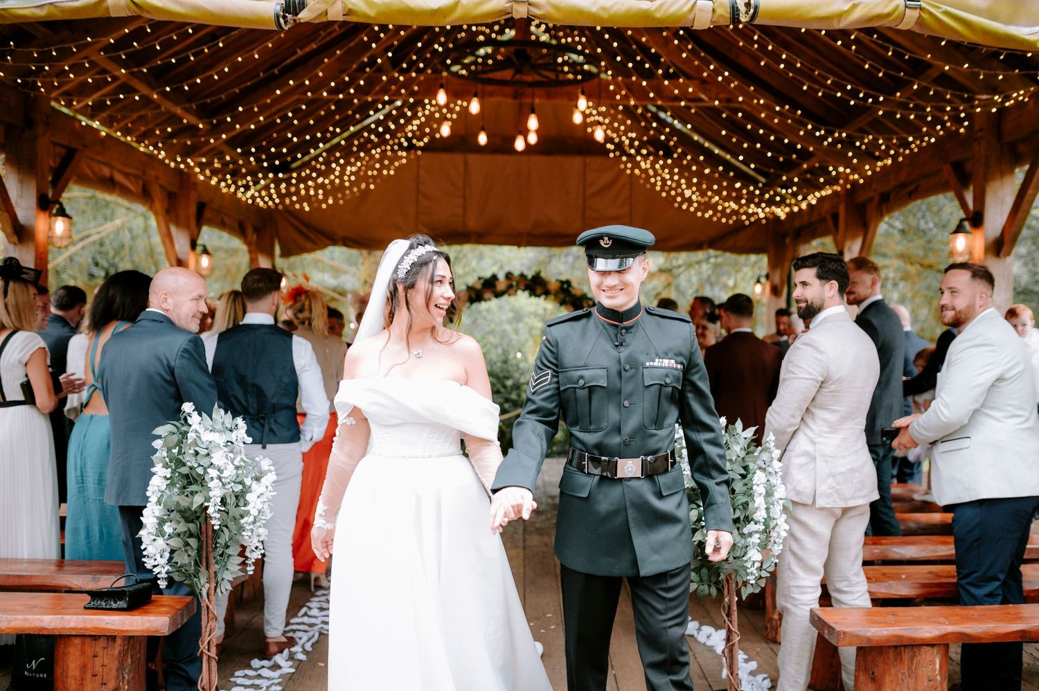 Wedding reception venue decorated with warm string lights and guests celebrating.
