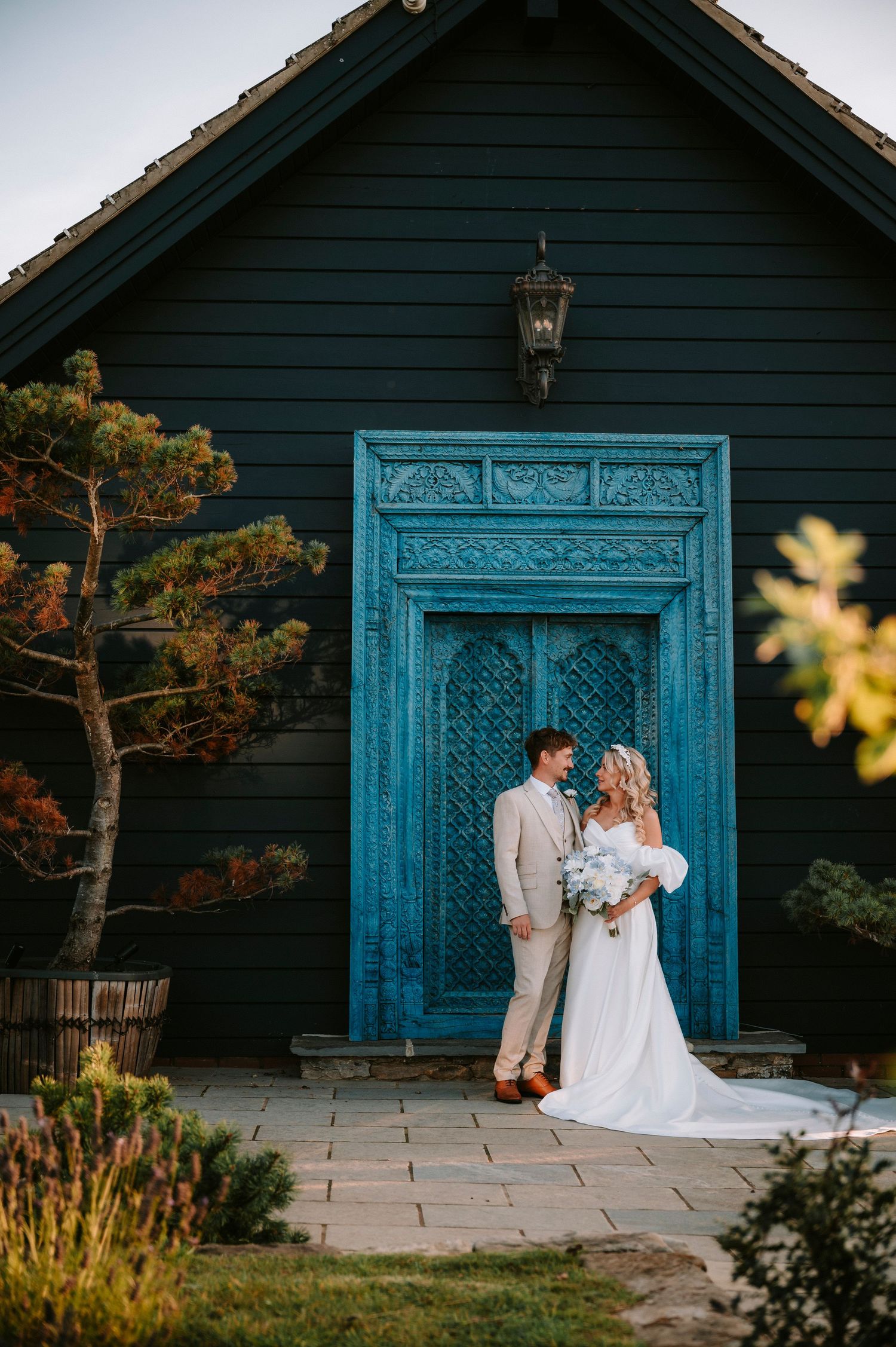 A charming wedding venue with a distinctive blue door against dark wooden walls.