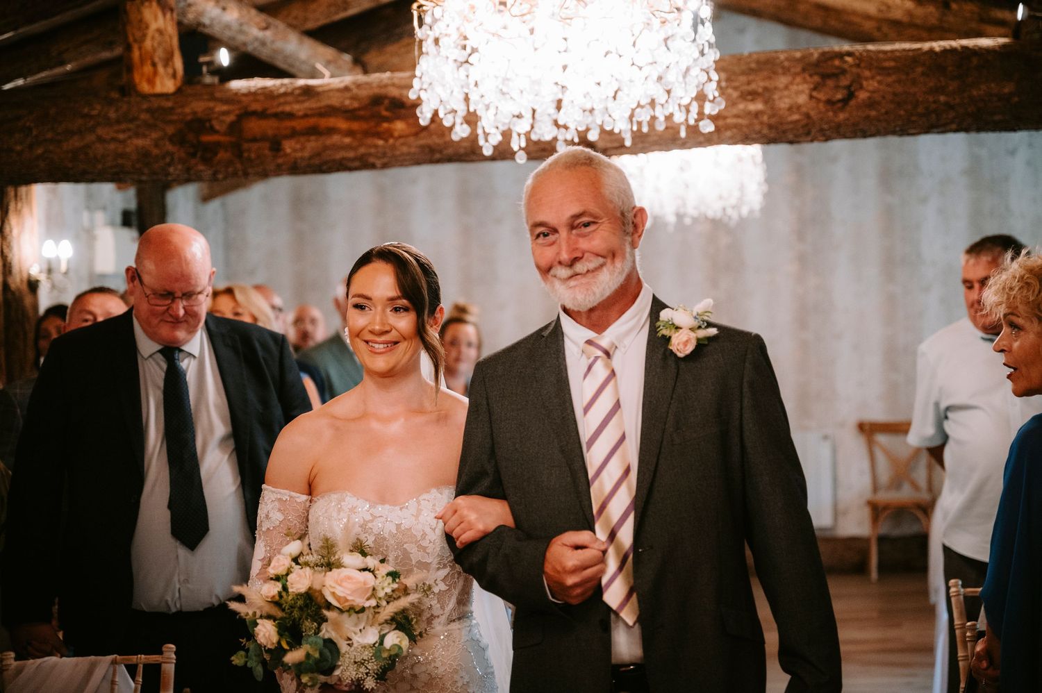 Wedding reception celebration in an elegant venue with crystal chandelier.