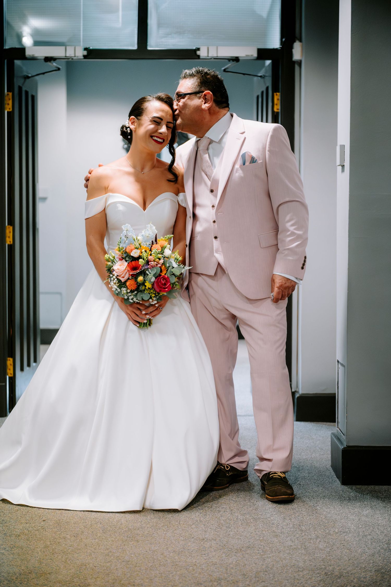 Candid wedding photos showing tender moments between newlyweds in a modern indoor setting.
