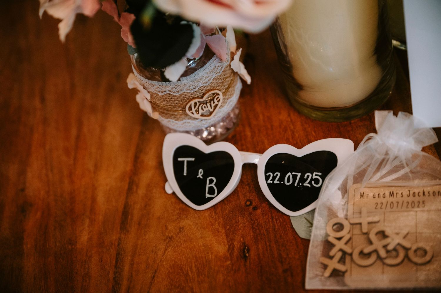 Wedding details and decorative items arranged on dark wooden surface.