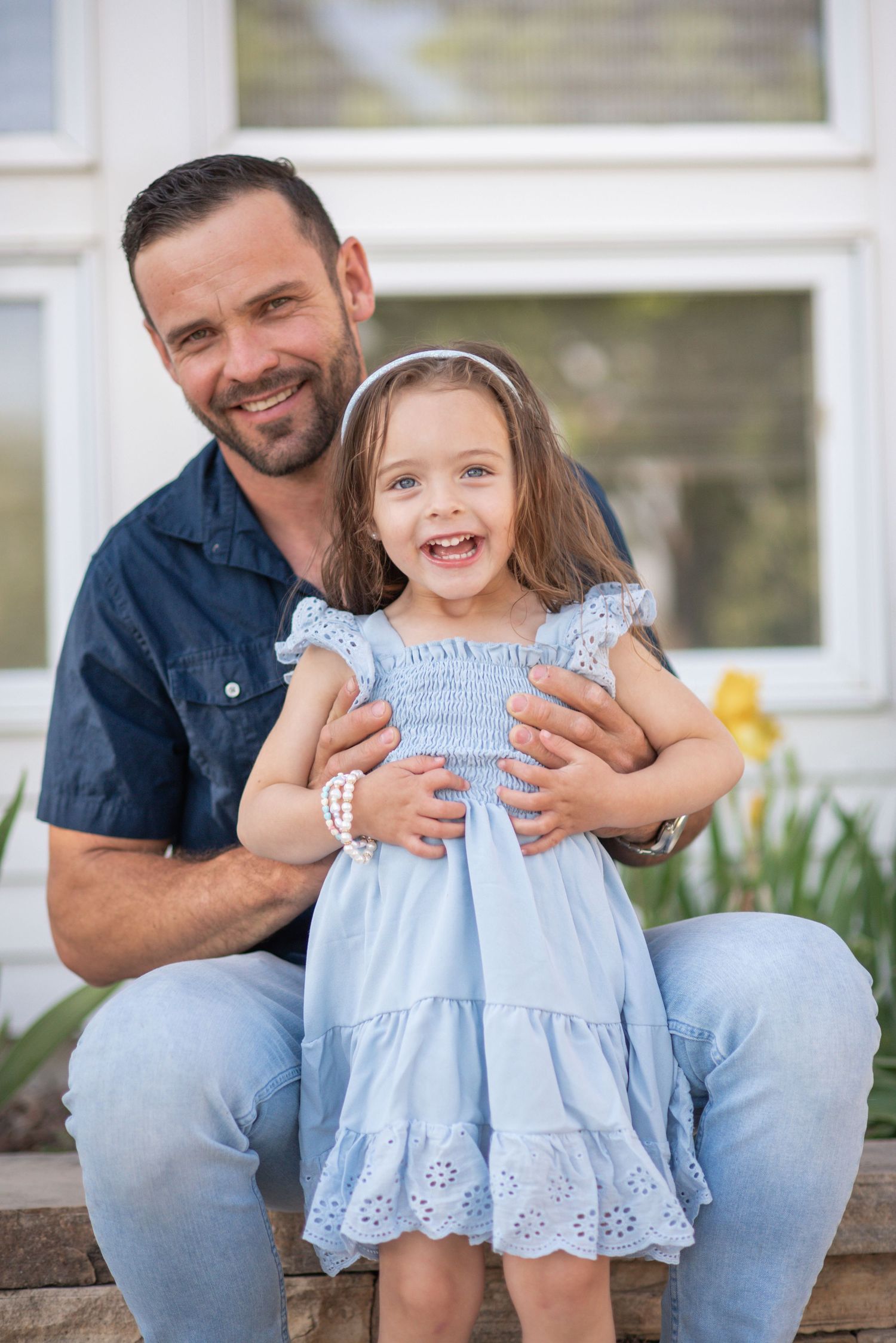 Father and daughter laughing pose for spring photos in a family photography session at Sandstone Ranch, Longmont Co Spring Colors Blue