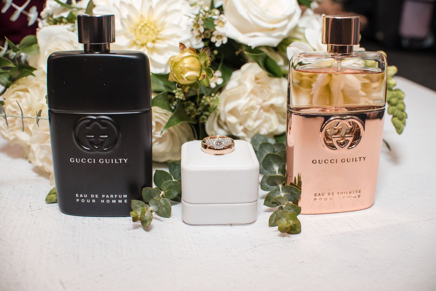 Details of couples' perfume and Cologne with a wedding ring and bouquet, pre-wedding photo ideas