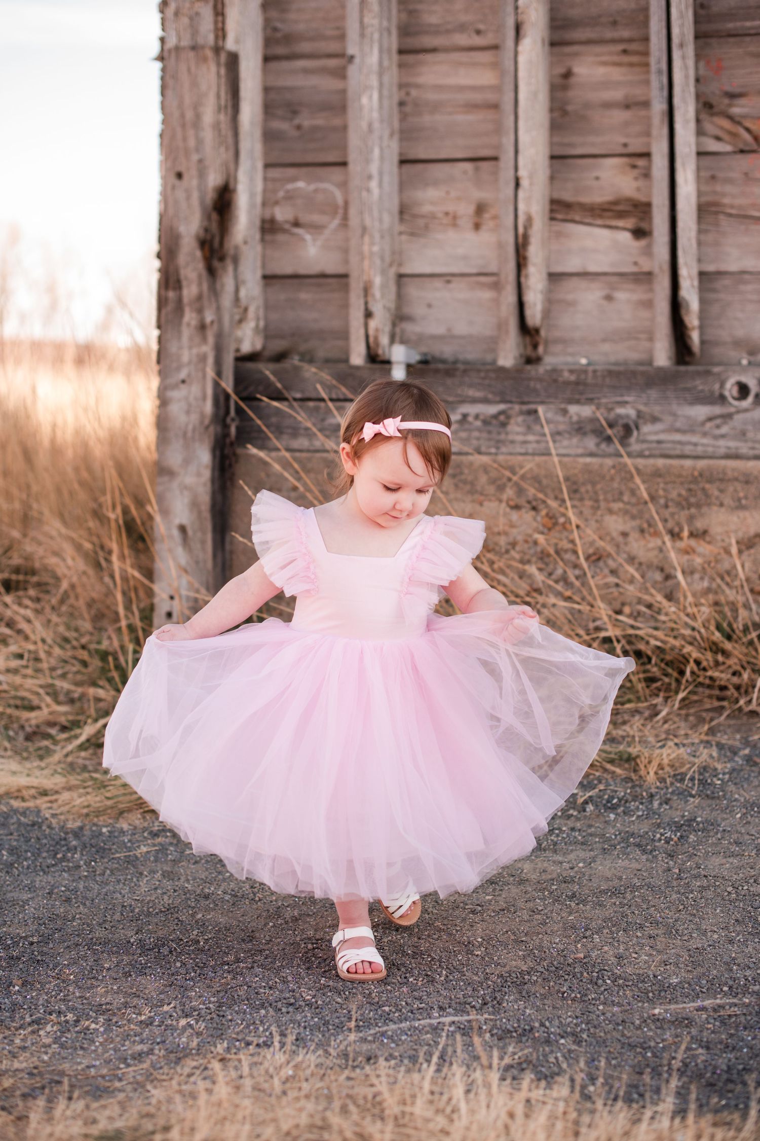 Longmont Family Photographer, outdoor near the rustic barn at Sandstone Ranch,  Bright and airy pink dress, playful child photography