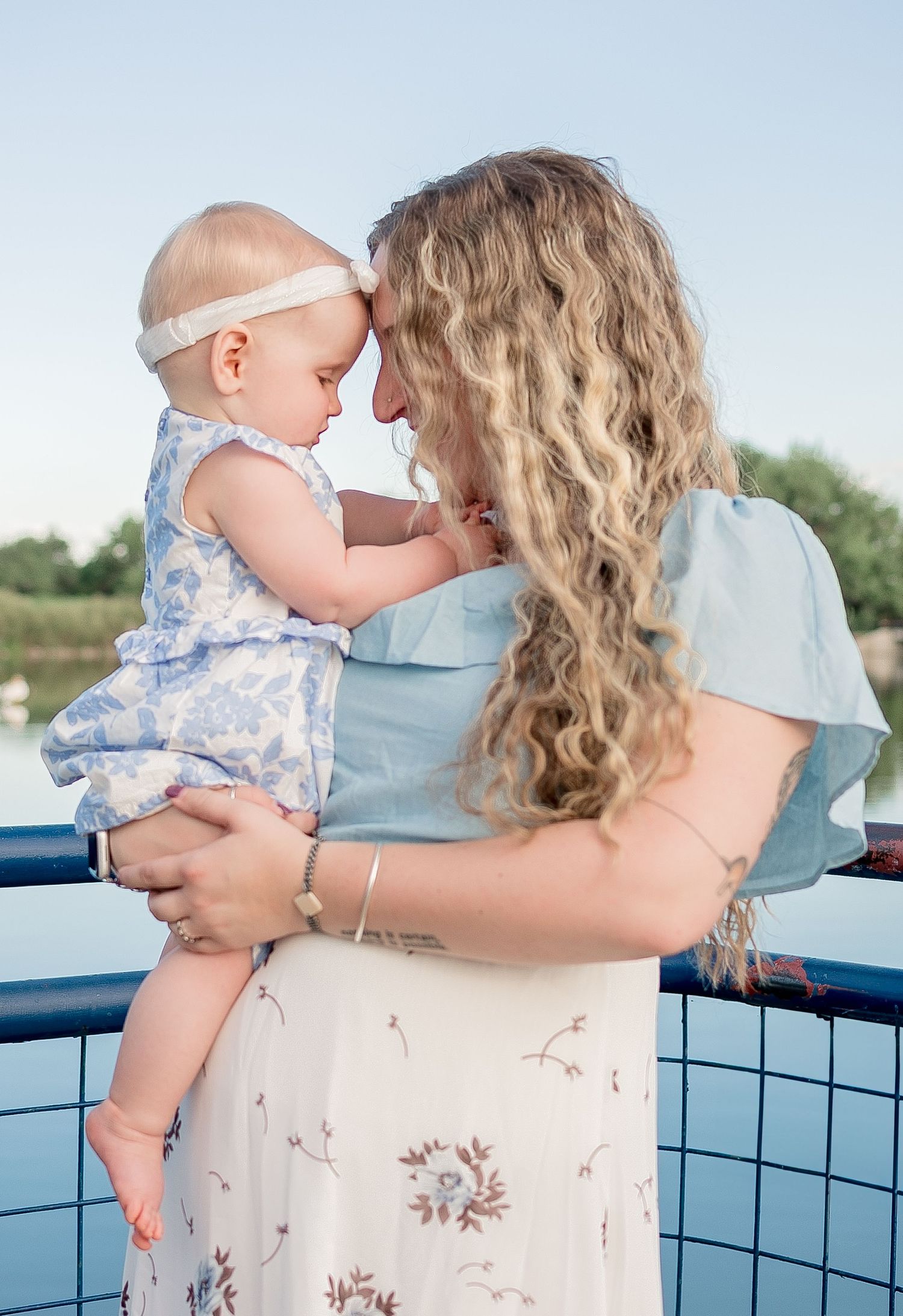 Family photography, mother and baby photo on pier, true to life colors, spring blue at the Golden Ponds, Longmont by Angelice Caballer