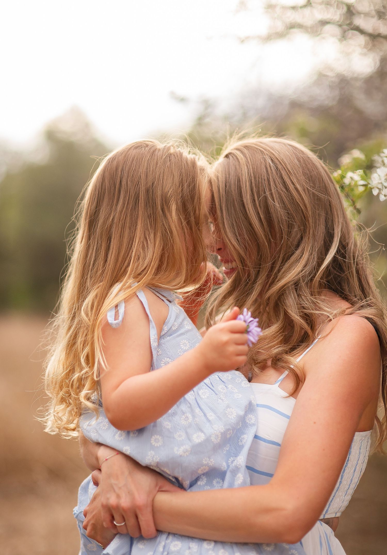 Family photography, Mother and daughter pose forehead to forehead true to life colors, spring at Rogers Grove, Longmont by Angelice Caballer