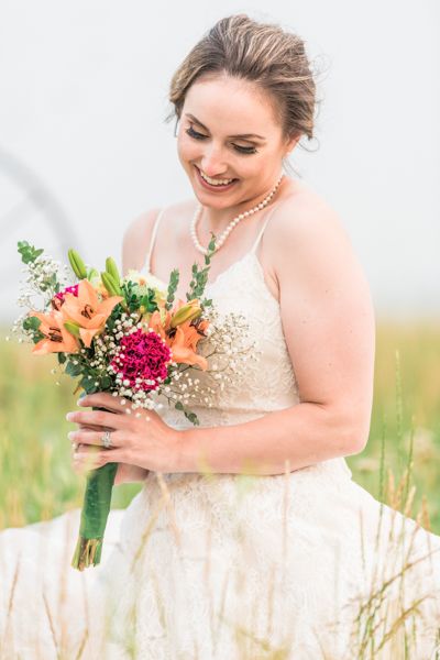 Bridal portrait, looking down at flowers sitting in spring grass, true to life style, Stillwater Ranch Venue photography  Angelice Caballer