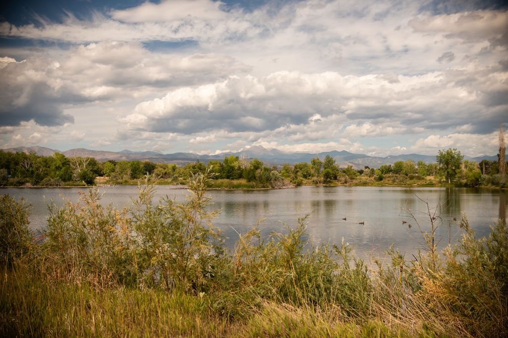 Front Range mountain views over the lake at Golden Ponds Nature Area, a popular family photography spot in Longmont, CO.