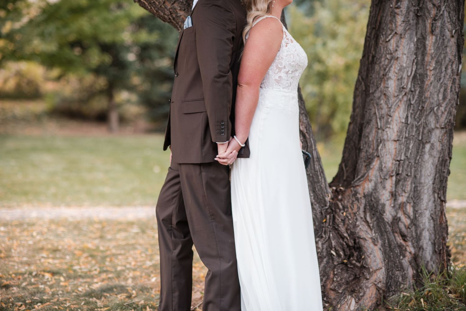 First touch ideas behind a tree, a couple holds hands and reads their first vows, Ellis Ranch, Loveland Fall wedding, inspo