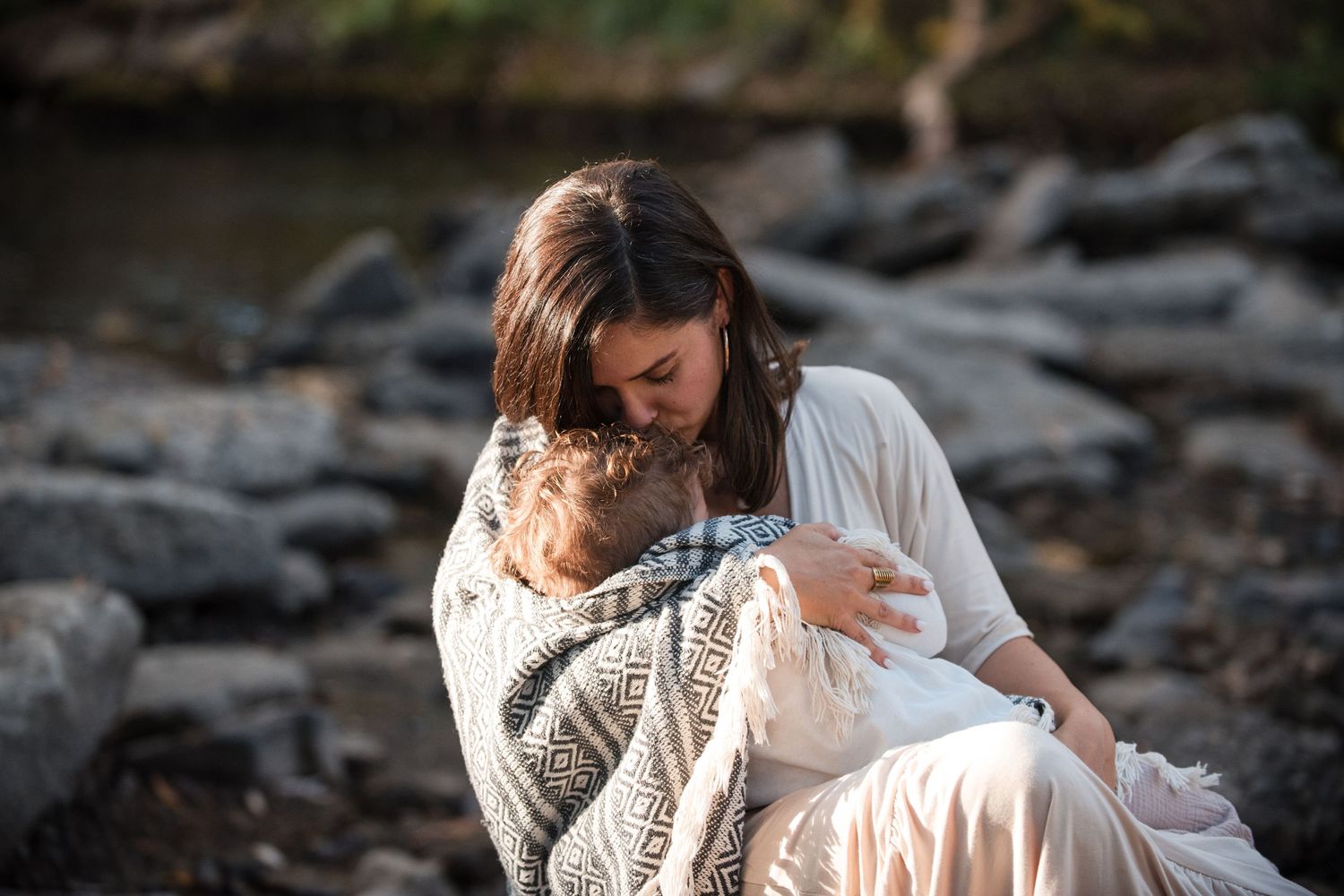 Mother feeding child as the season changes  in front of the waterfall, Longmont-CO-family-photographer-outdoor-session
