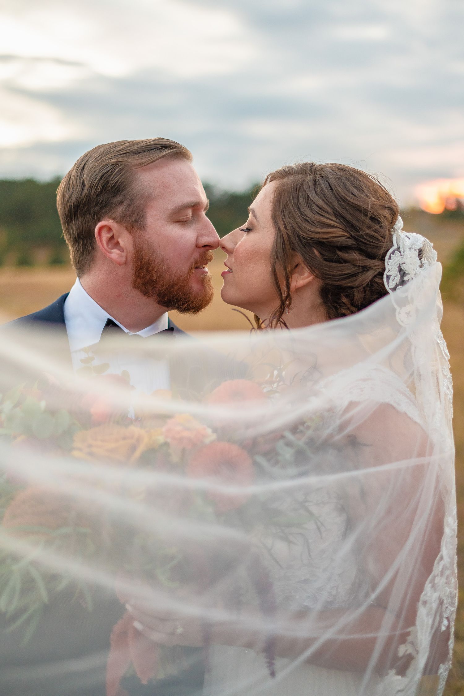 A beautiful wedding couple standing together during sunset, with the stunning backdrop of the Mount Vernon Canyon Club in Golden, Colorado.