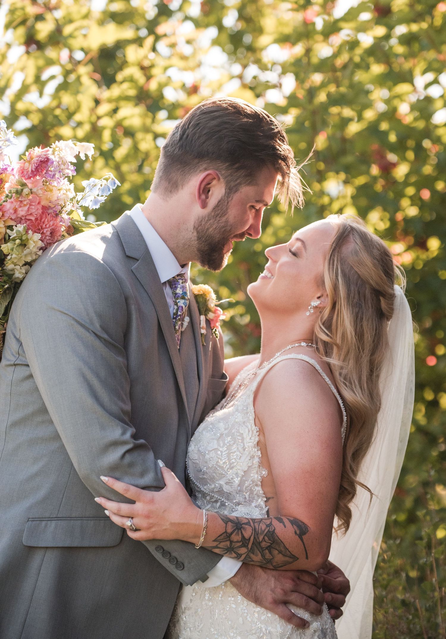 Wedding couple embraces just before a kiss, showing the bouquet in a great pose for formals. At Estes Park Resort, Angelice Caballer Photos