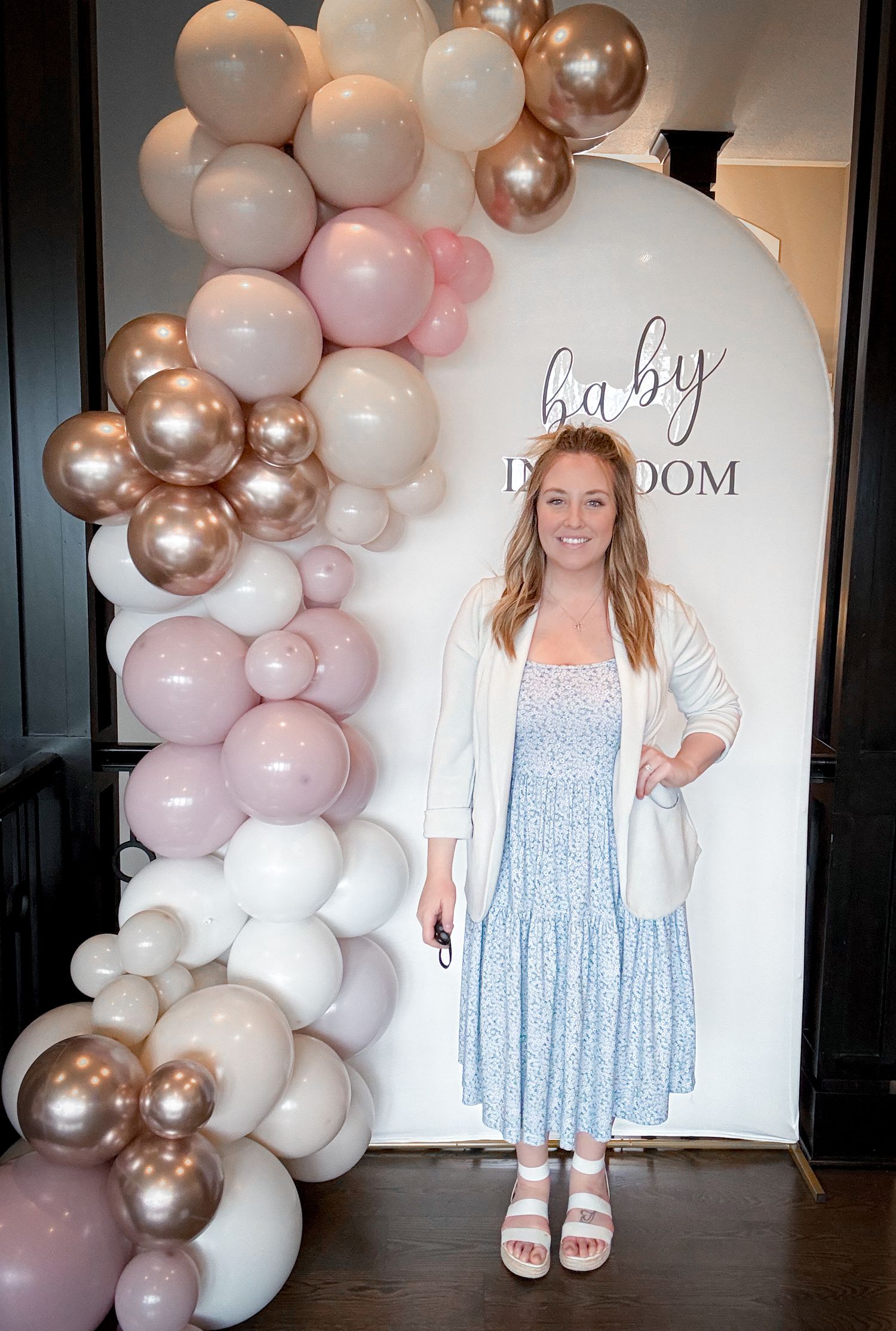 Female standing beside balloon backdrop display for birthday event styling Kansas City