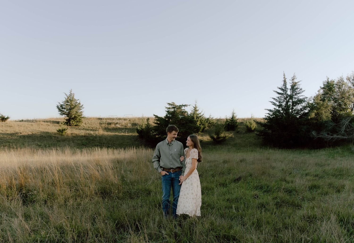 Romantic couple walking through tall grass in a golden field during sunset with multiple perspectives shown.