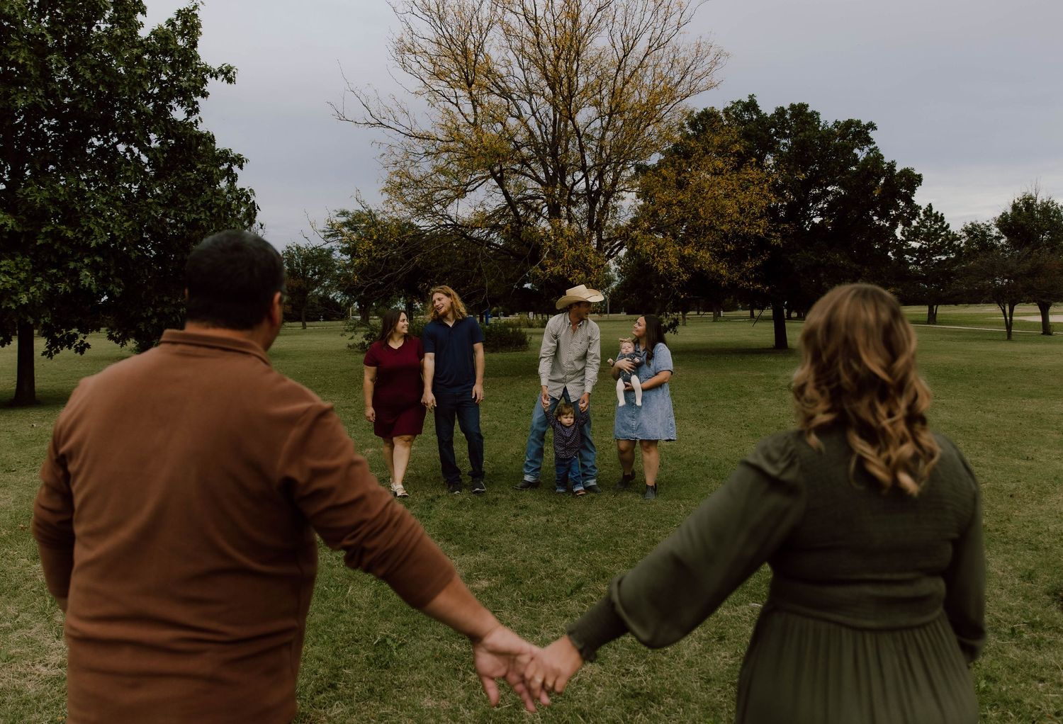 Group walking together through grassy meadow at dusk.