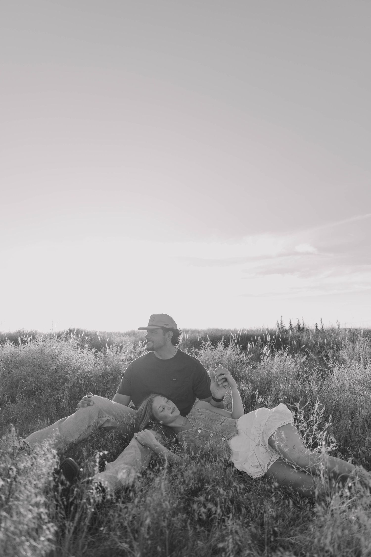 Black and white portrait session in tall grass meadow.