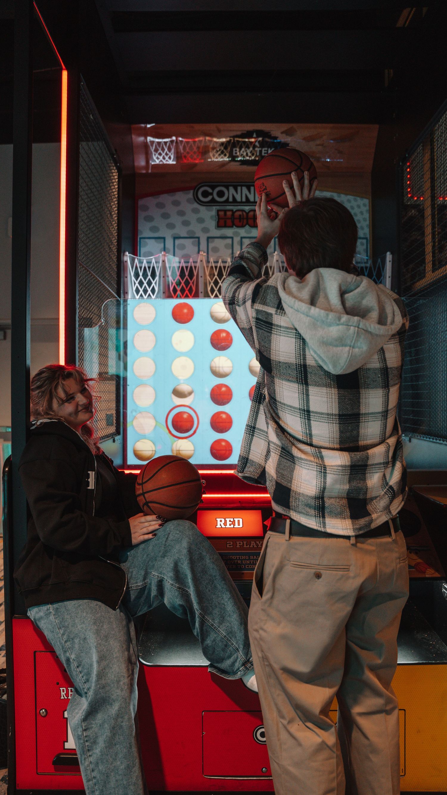 Couple photoshoot at round1 Arcade in Towson Maryland ( Baltimore County) Girl watching guy playing basketball