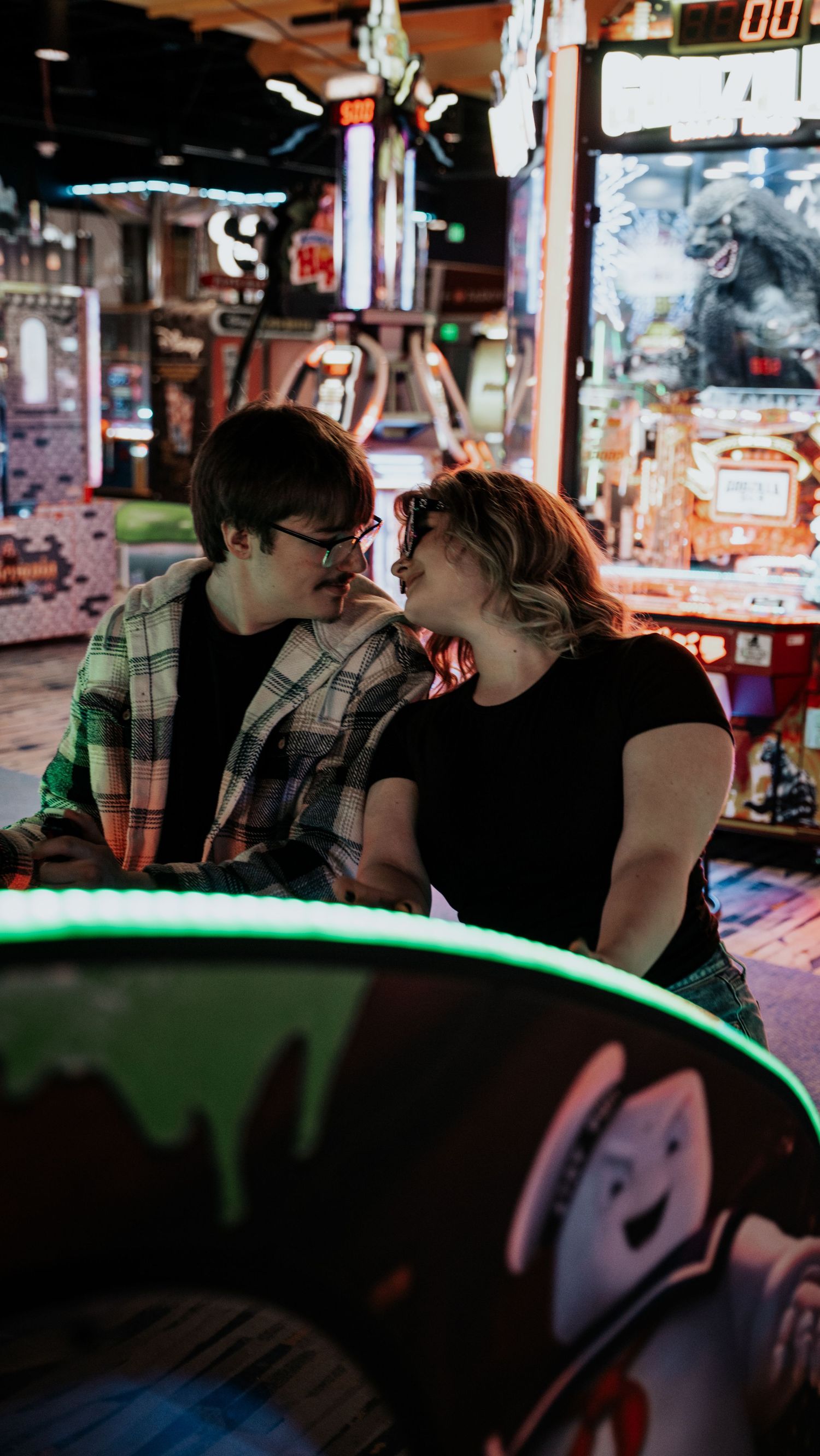 A young couple shares a romantic moment together while sitting at an arcade game machine. In Towson Maryland