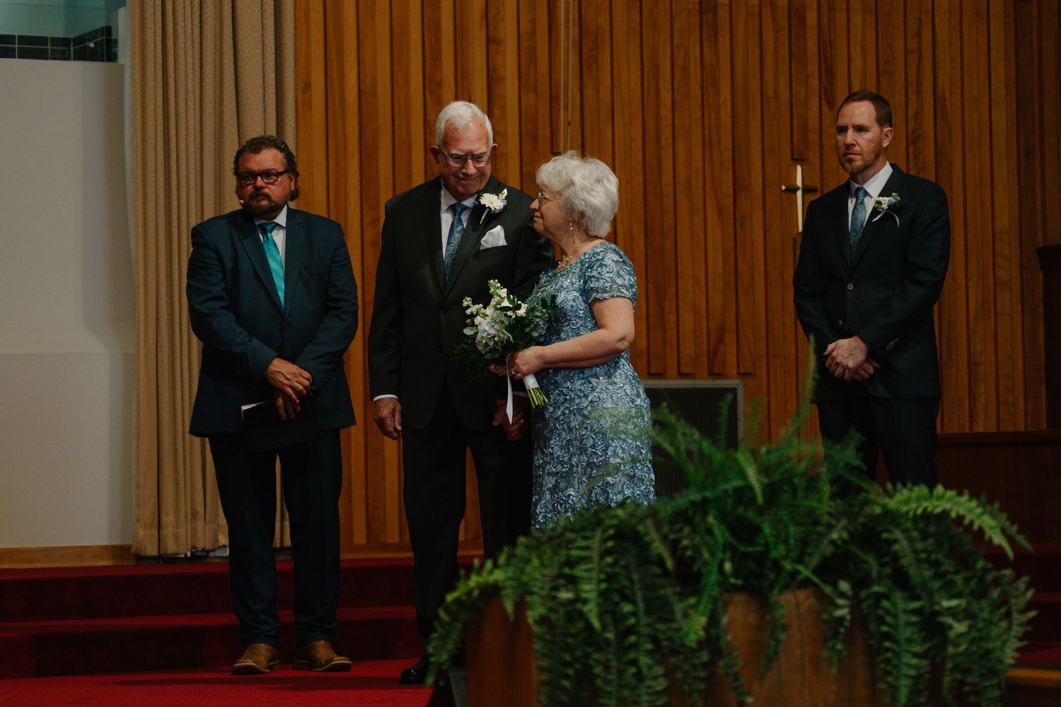 Elderly couple stands at church altar with bouquet, flanked by two men in suits during a wedding ceremony. In Bel Air Maryland