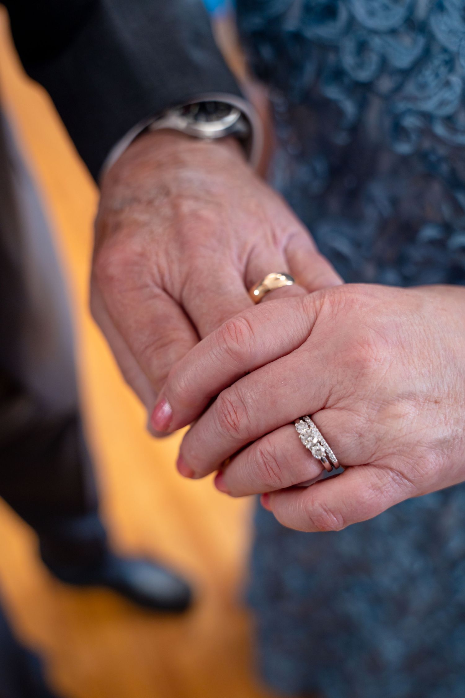 Bel Air Maryland Elderly couple holding hands showing wedding rings, man wearing gold band and woman wearing diamond engagement ring set.