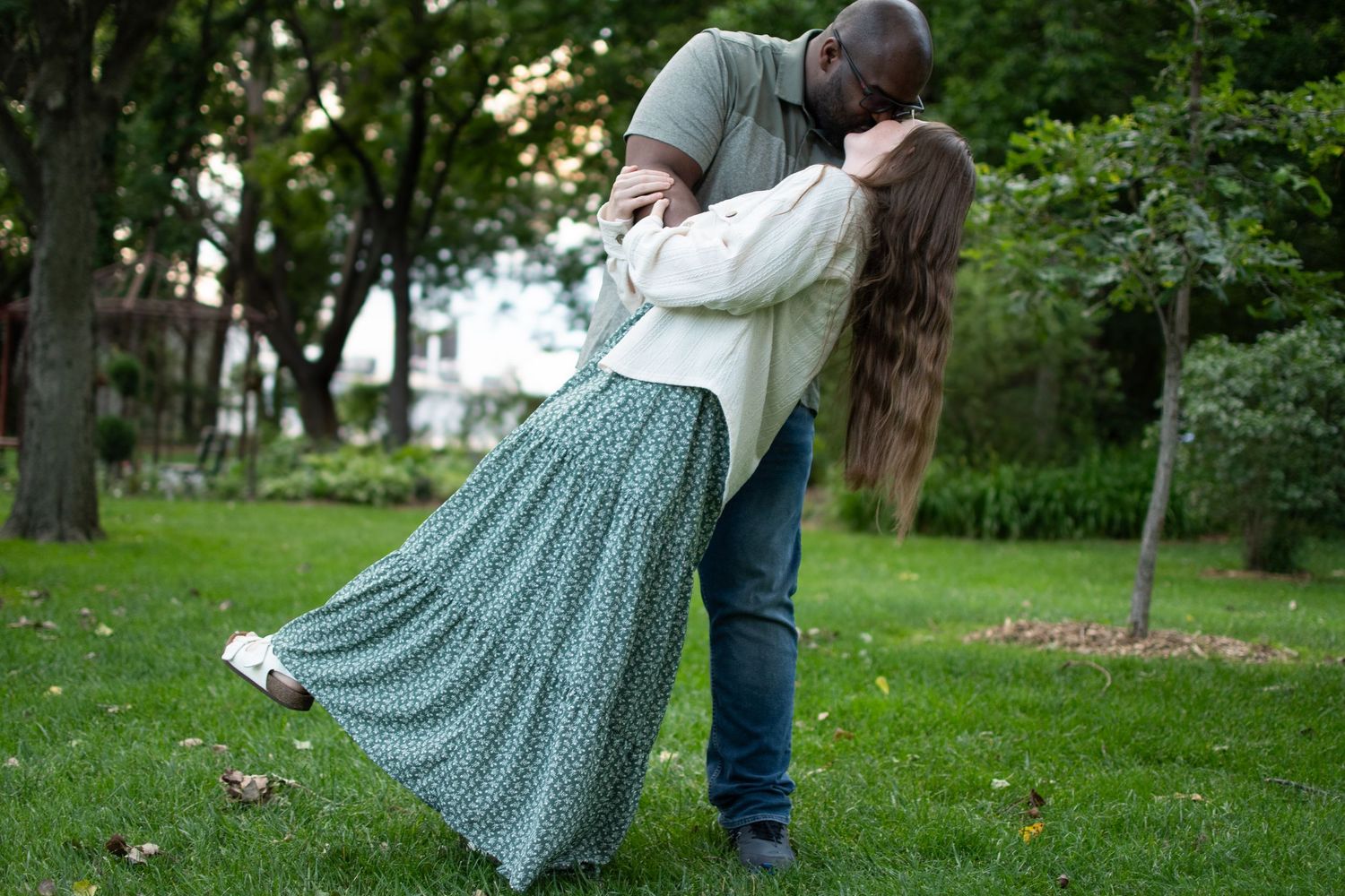 True-to-color portrait of a man dipping and kissing a woman in a green dress in Grand Island, Nebraska.