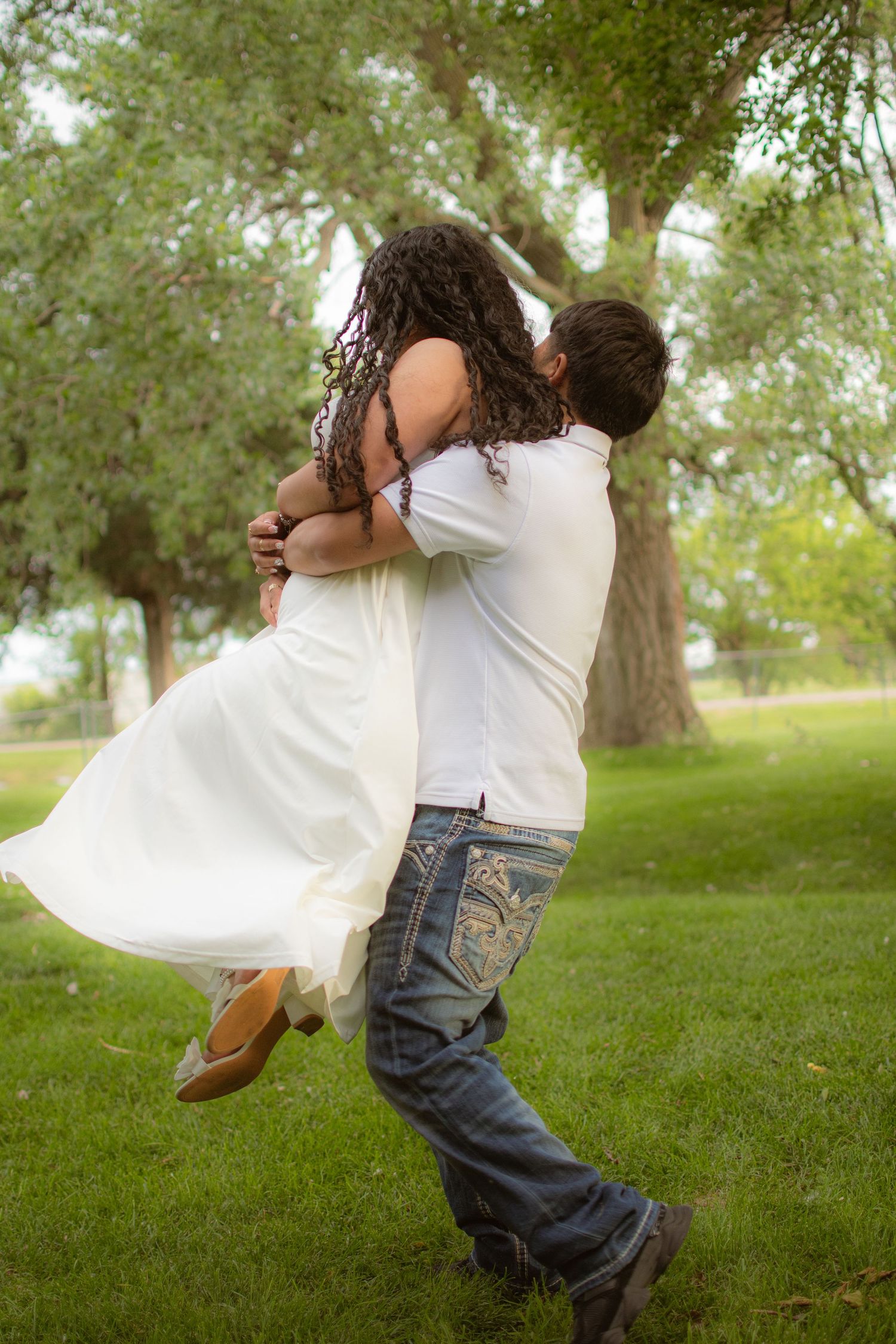 Candid, vibrant true-to-color portrait of a couple playing in a grassy field in Grand Island, Nebraska.