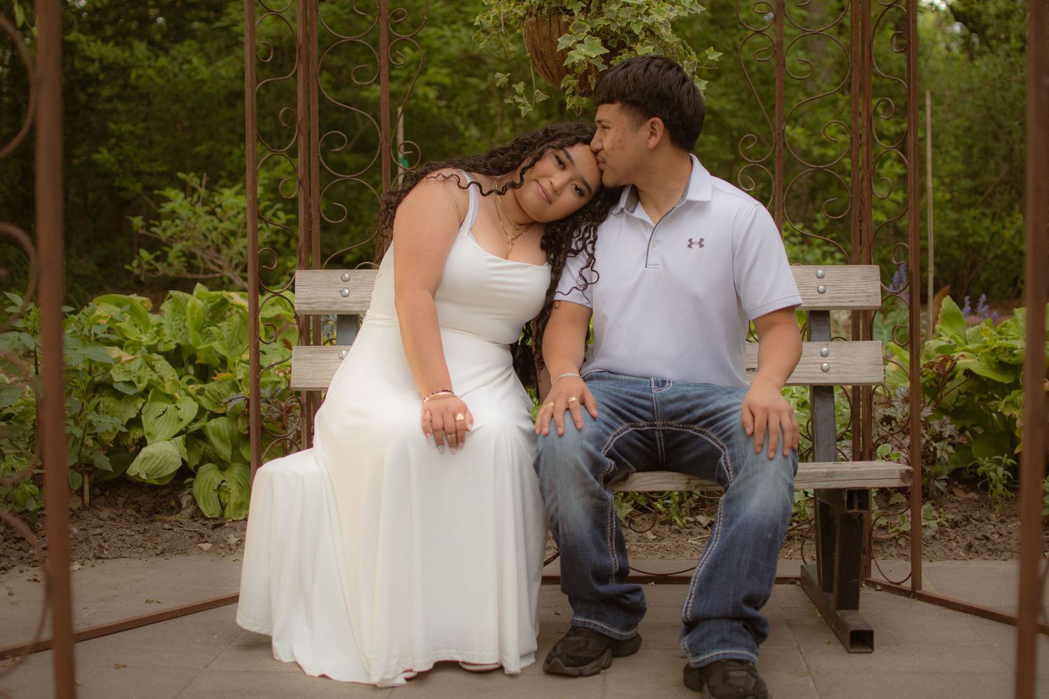 Dreamy, true-to-color portrait of a young couple embracing on a park bench at Hall County Park in Grand Island, Nebraska.